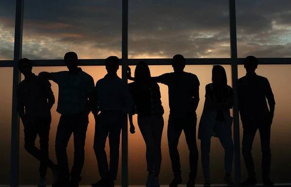 Equipe de negócios em pé perto da janela, noite, escuro — Fotografia de Stock