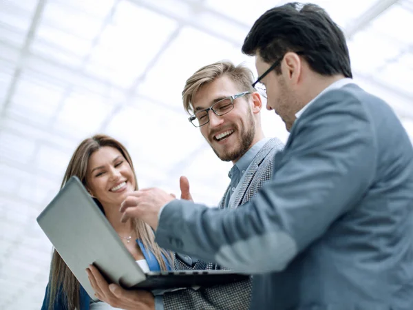 De cerca. sonriente equipo de negocios mira a la pantalla del ordenador portátil — Foto de Stock