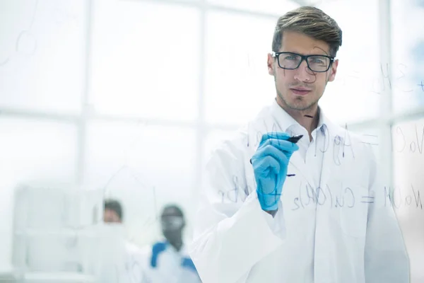 Scienziato prendere appunti sul bordo di vetro al momento dell'esperimento — Foto Stock