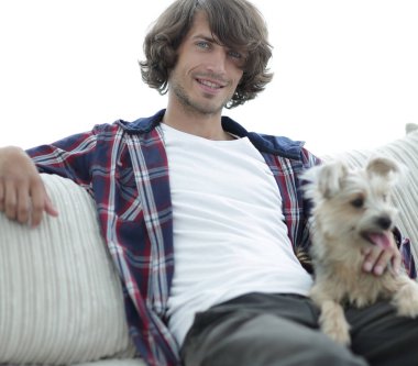 şık adam köpeğiyle kanepede oturan.