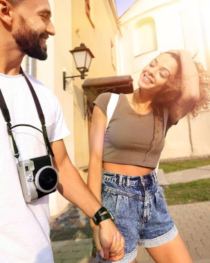 Bir çift şehrin sokaklarında yürüyor ve eğleniyor.