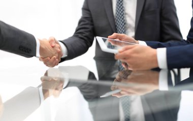 Bir toplantı sırasında el sıkışan iki emin iş adamları