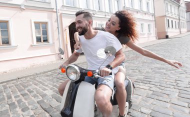 mutlu genç bir çift bir scooter üzerinde eğleniyor