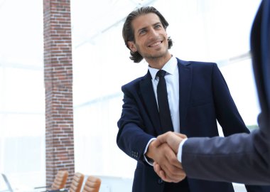 İş ortakları el sıkışarak ortağa hoş geldin diyor