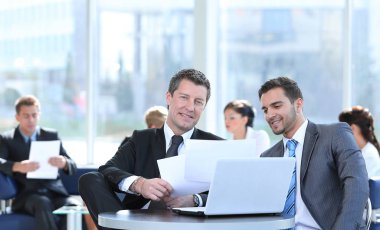 iş ortakları bankanın lobisinde otururken mali konuları tartışmak