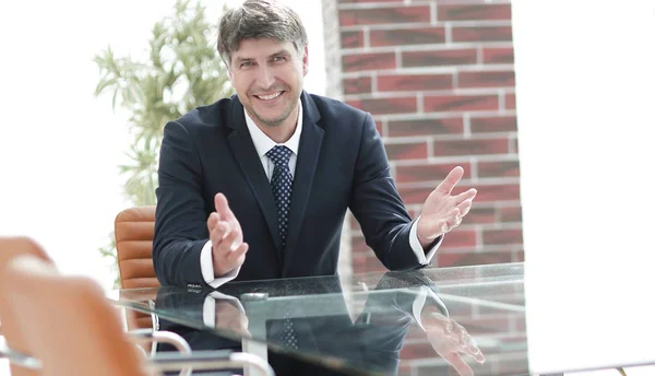 Successful businessman sitting in an empty desk — Stock Photo, Image