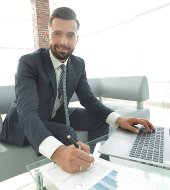 İş grafikleri ile bir dizüstü bilgisayar üzerinde çalışan iş adamı