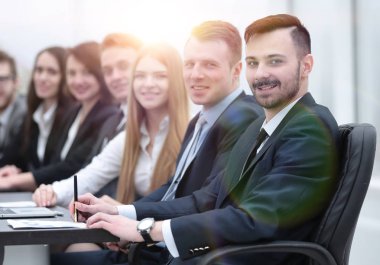 İş ekibi konferans odasındaki masada oturuyor.
