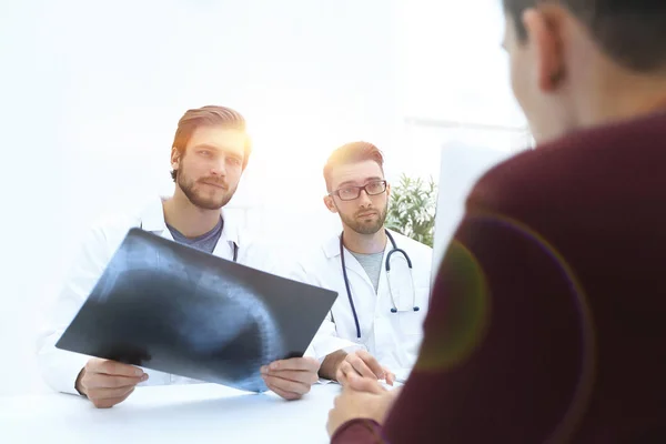 Två läkare undersöker en röntgenbild av en patient — Stockfoto