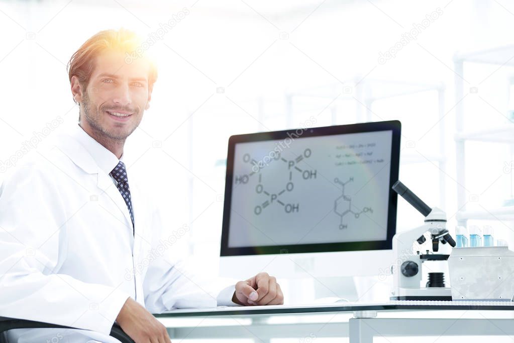 Portrait of a male scientist with a monitor looking at the camer