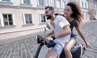 mutlu genç bir çift bir scooter üzerinde eğleniyor