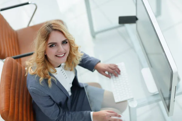 Lächelnde Geschäftsfrau sitzt hinter einem Schreibtisch — Stockfoto