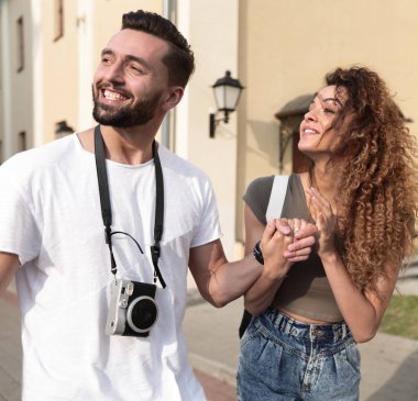 Bir çift şehrin sokaklarında yürüyor ve eğleniyor.