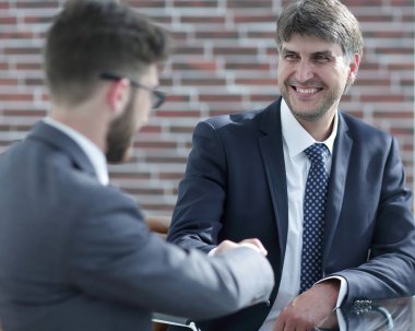 İş adamları el sıkışır, masada otururlar. .