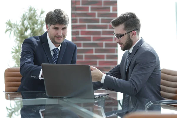 Zwei Geschäftsleute arbeiten im Büro an einem Laptop — Stockfoto