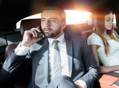 Seyahat sırasında cep telefonu ve laptop kullanan işadamları