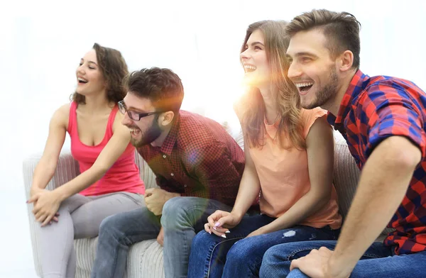 Skupina mladých lidí, kteří sedí na gauči s úsměvem — Stock fotografie