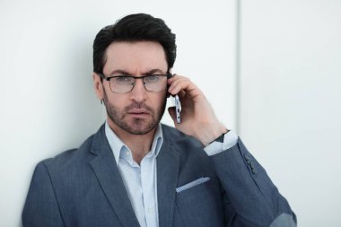 Yakışıklı iş adamı telefonda konuşuyor.