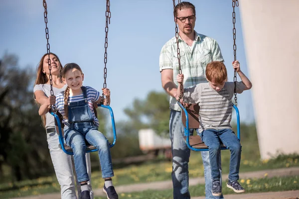 Oyun alanında oynayan iki çocuklu çift