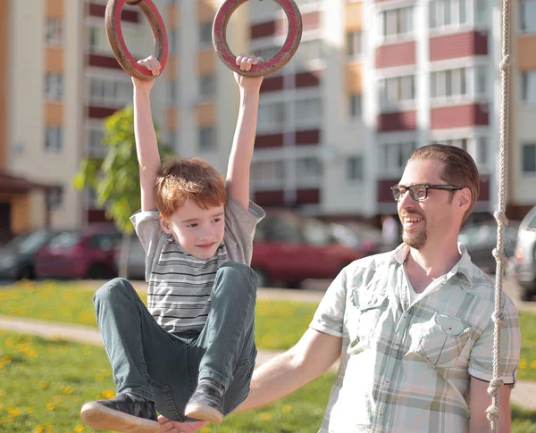 Far och son på lekplatsen — Stockfoto