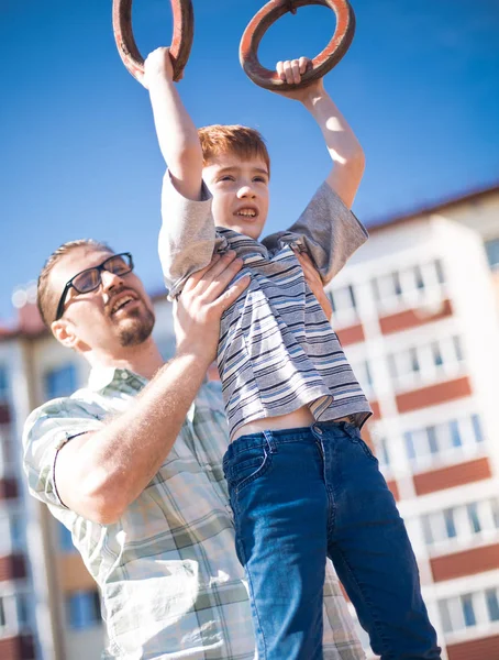 Far hjälper till sin son att komma ikapp på baren — Stockfoto