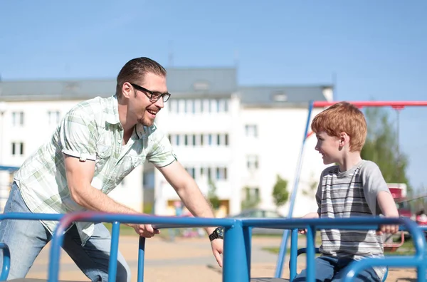 Unga far och Lille son på lekplatsen — Stockfoto