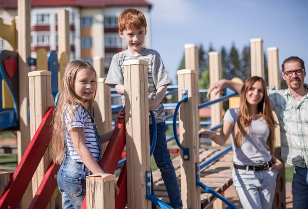 Barnen leker med sina föräldrar på lekplatsen — Stockfoto