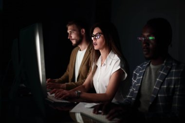 Geceleri bir bilgisayar önünde bir ofiste oturan mali takım