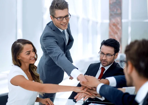 Equipe de negócios unindo as mãos sobre a mesa — Fotografia de Stock