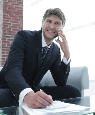 İş yerinde akıllı telefonu olan bir iş adamı.