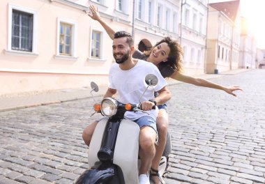 mutlu genç bir çift bir scooter üzerinde eğleniyor