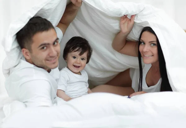 담요 아래 침대에 아이 들과 함께 가족 — 스톡 사진