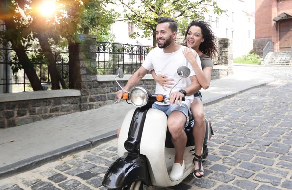 Elegante jovem casal senta-se uma scooter na rua . — Fotografia de Stock