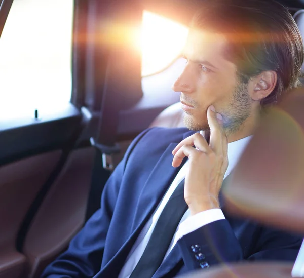 Serious businessman sitting in car — Stock Photo, Image