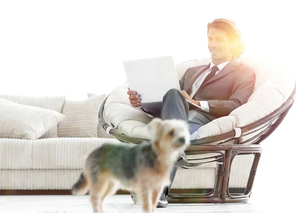 Modern businessman with laptop sitting in living room. — Stock Photo, Image