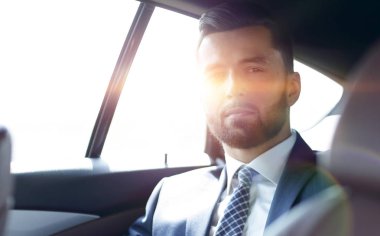 arabanın arka koltuğunda oturan yakışıklı sakallı işadamı