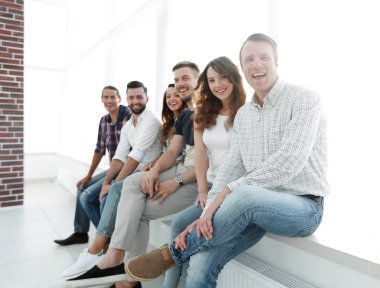 bekleme odasında sandalyelere oturan genç yaratıcı insanlar