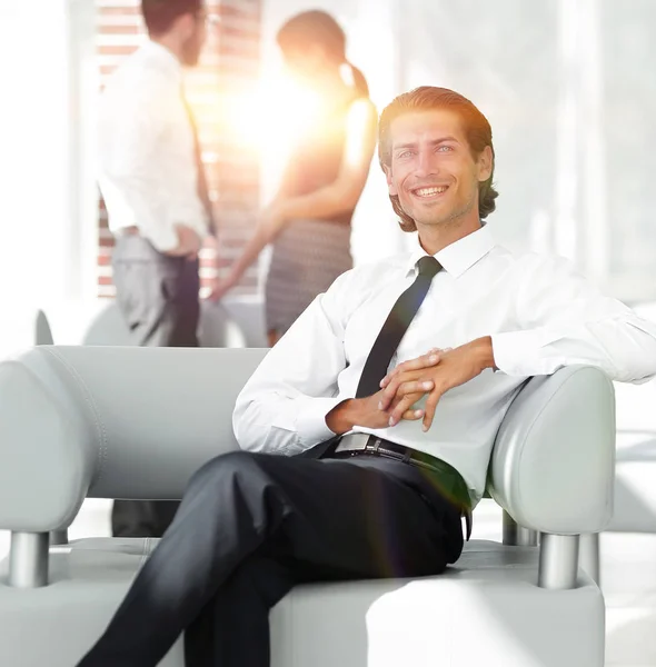 Uśmiechający się biznesmen, siedząc w fotelu biurowym — Zdjęcie stockowe