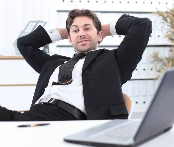 Uomo d'affari si rilassa seduto dietro una scrivania — Foto Stock