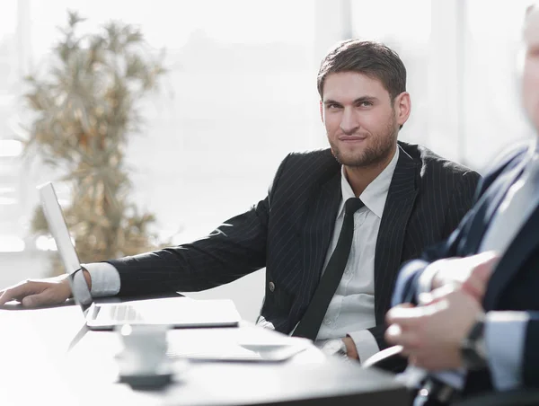 Empresário de sucesso com seu colega sentado atrás de uma mesa . — Fotografia de Stock