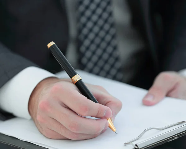 Affärsman tecknar avtal. Håller pennan i hand. — Stockfoto