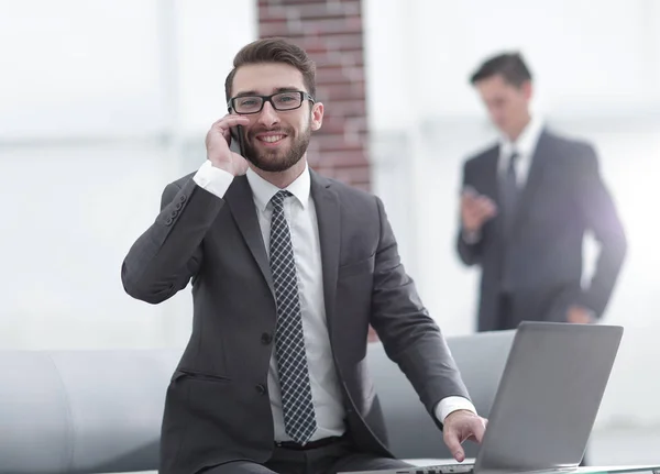 Jeune homme confiant parlant au téléphone au bureau — Photo