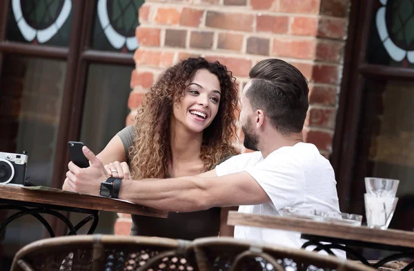 Porträt eines jungen Paares, das sich auf eine Caféterrasse setzt — Stockfoto