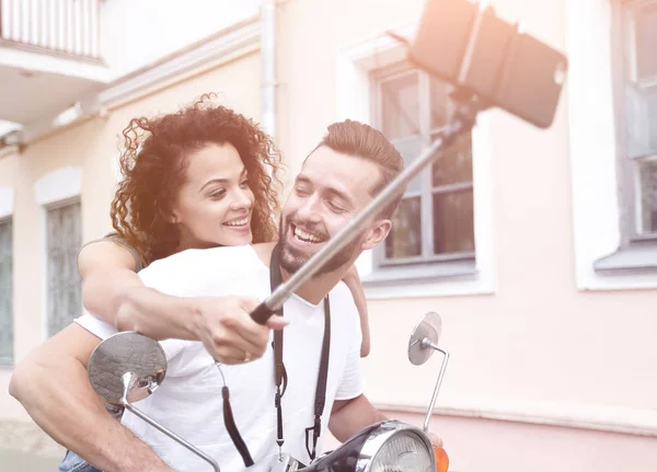 Pareja feliz en scooter haciendo selfie en el teléfono inteligente al aire libre — Foto de Stock
