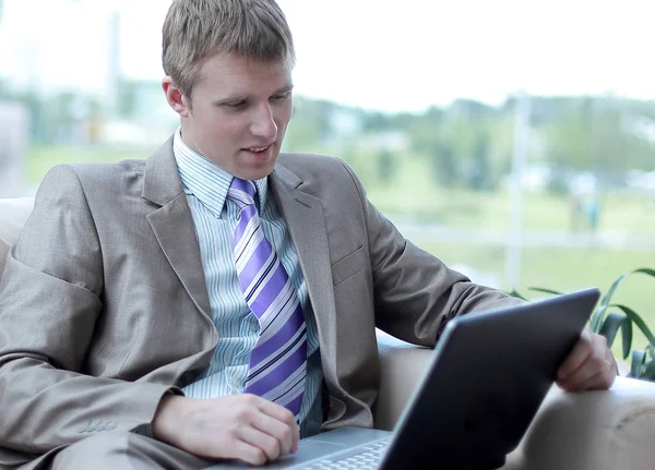 Jungunternehmer sitzt in Büro-Lobby und arbeitet mit Laptop — Stockfoto