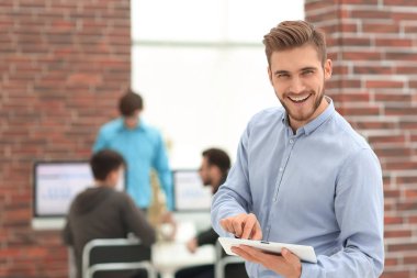 Ofiste tablet kullanan yakışıklı bir iş adamı..