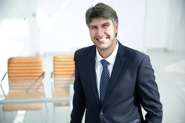 Exitoso hombre de negocios de pie junto al escritorio . — Foto de Stock