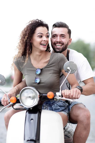 Young beautiful  couple riding on motorbike city street.