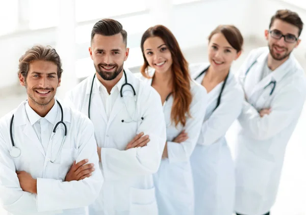 Медична команда, що стоїть з обіймами, схрещеними на білому тлі — стокове фото