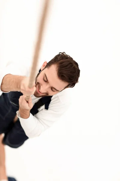 Construction worker climbing the rope up. — Stock Photo, Image